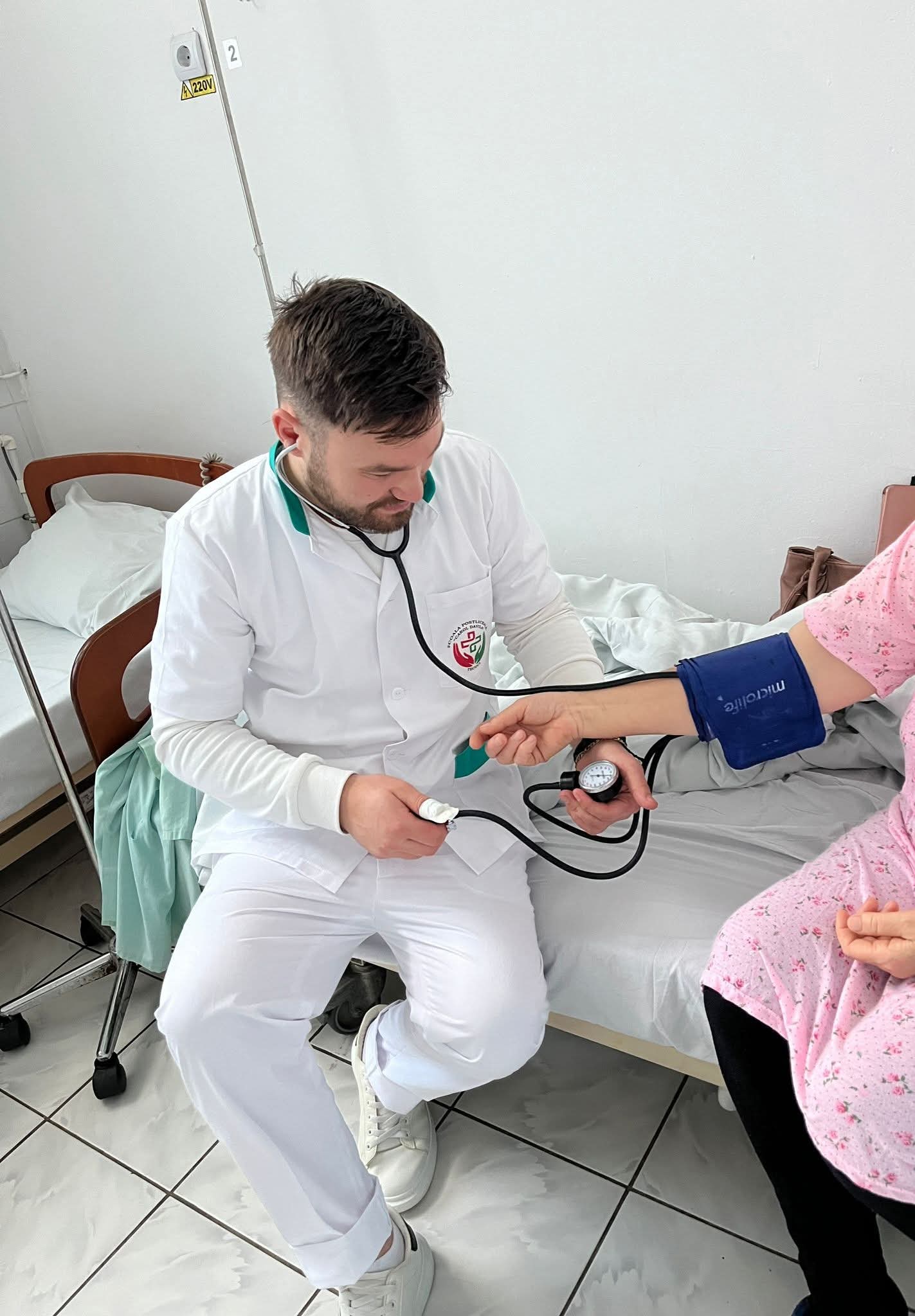Elev măsurând tensiunea arterială a unei paciente